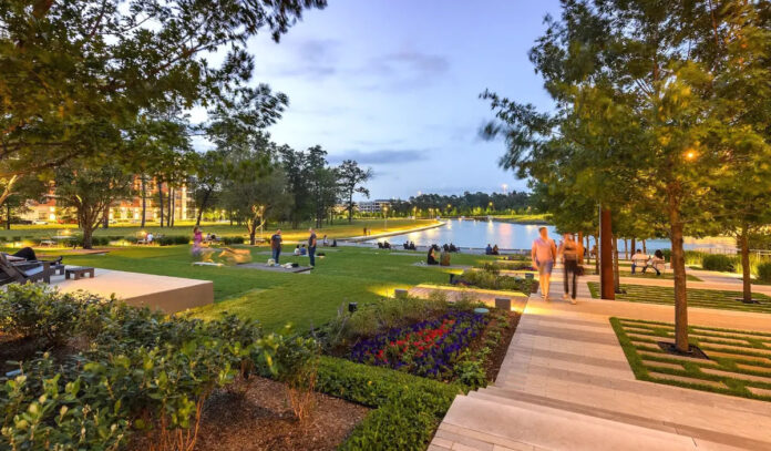 An evening scene of people strolling through a park