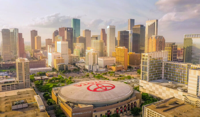 An aerial view of Toyota Center with Downtown skyscrapers in the background