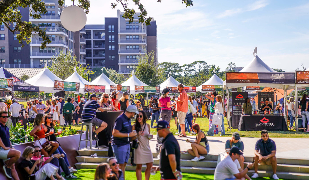 An outdoor food festival with people walking past booths