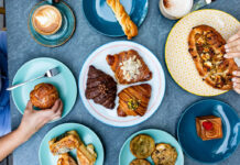 Where to Brunch Near Rice University An overhead view of multiple plates of croissants, breads, and other brunch offerings
