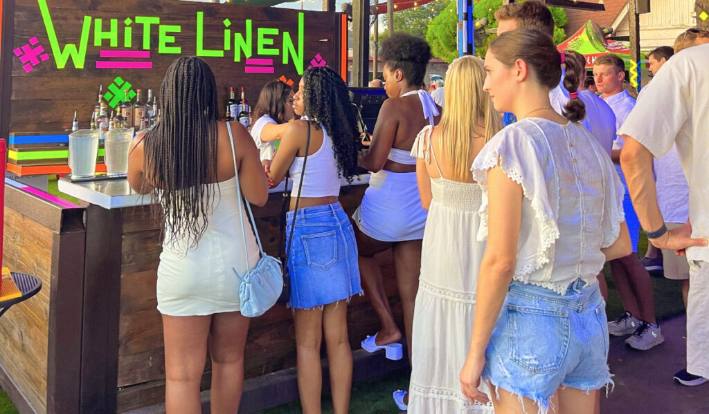 People waiting in line for drinks at a White Linen event