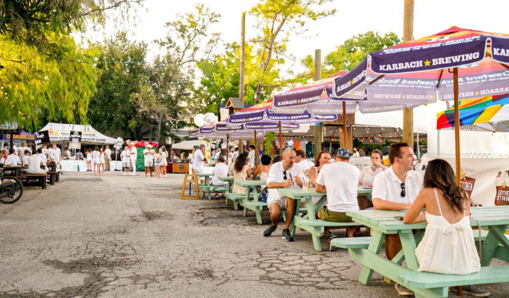 A row of picnic tables with people dressed in white