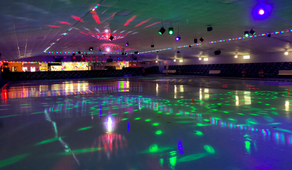 An empty roller rink with bright neon lights shining throughout