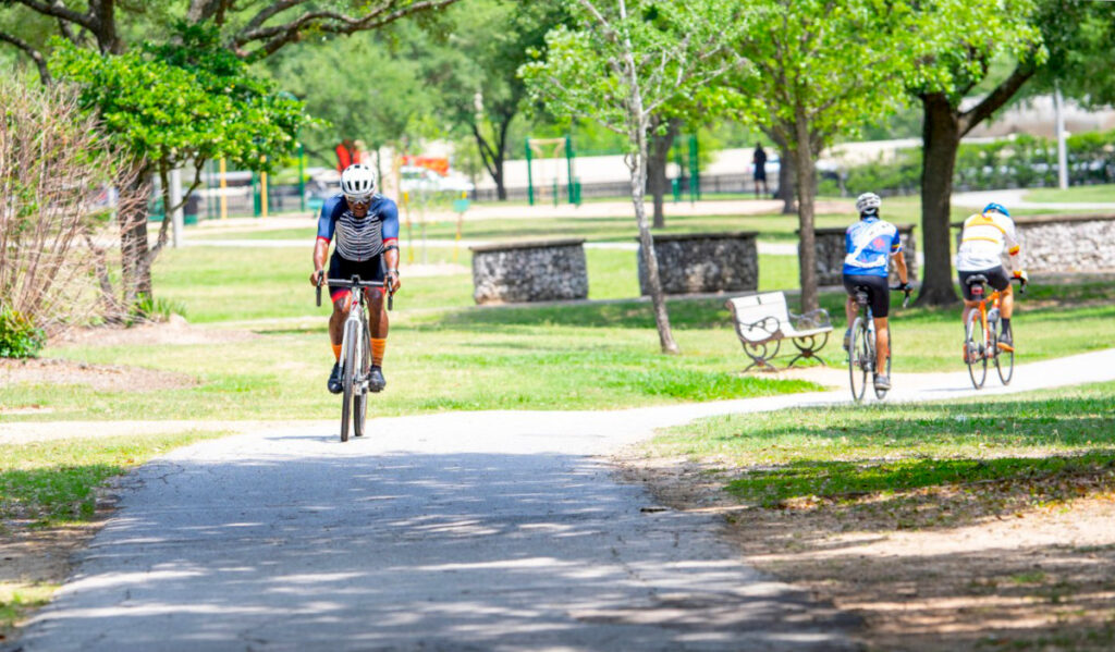 Three bicyclists pedaling a trail on a sunny day