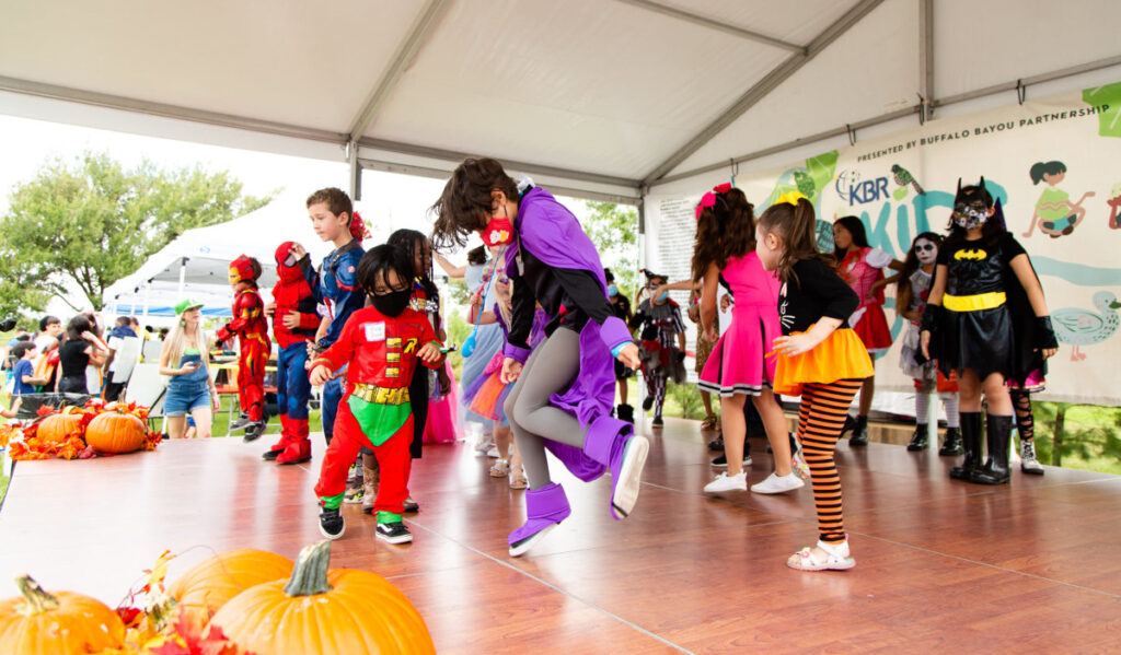 Kids in Halloween costumes dance on a stage