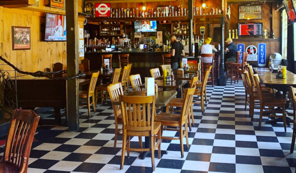 Interior of Rudyard's Pub with checkered floor, tables and seating