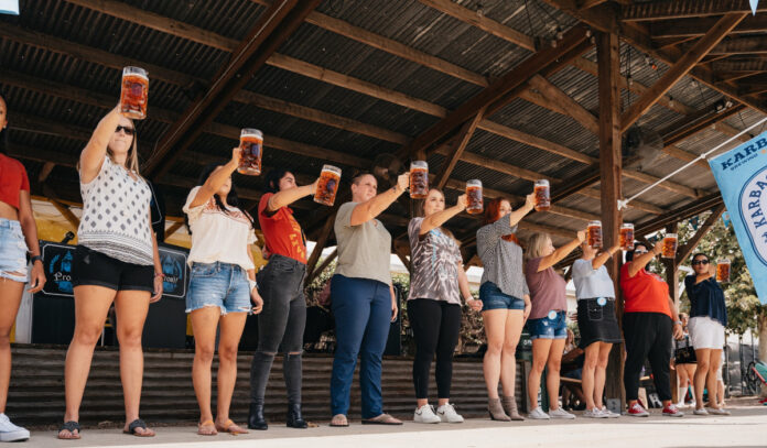 A line of women contestants holding full steins in front of their body