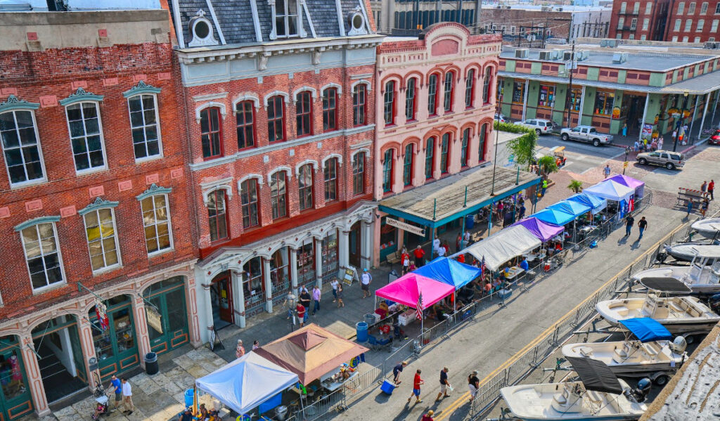 An aerial view of Downtown Galveston with stalls lined up outside historic buildings