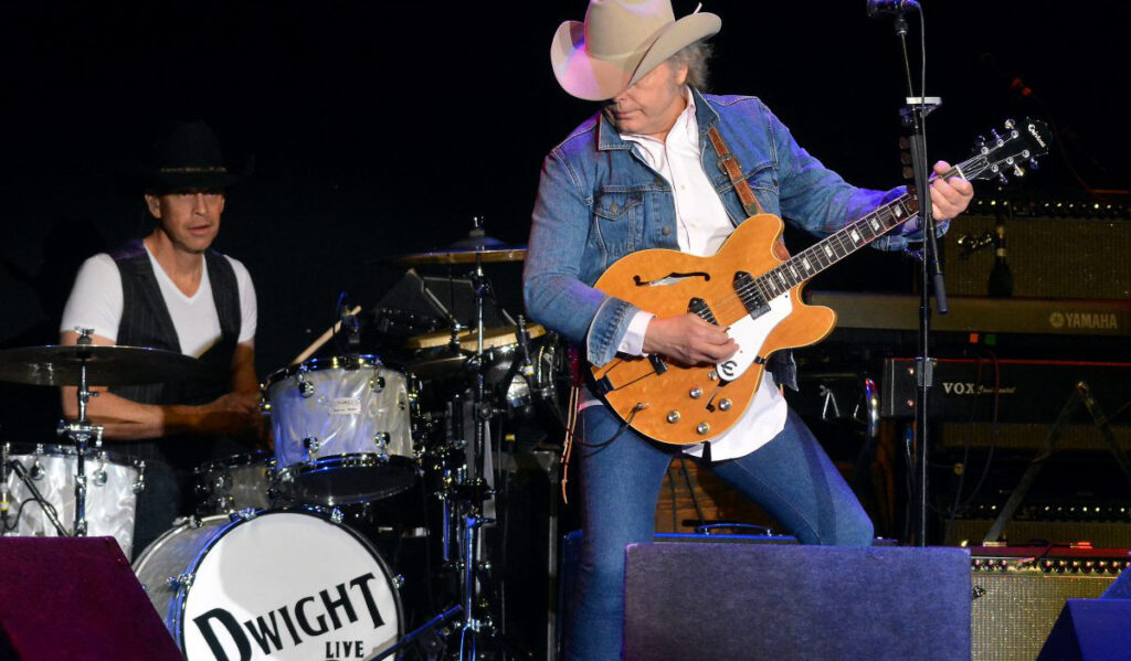 Dwight Yoakum performs on stage in a cowboy hat and denim