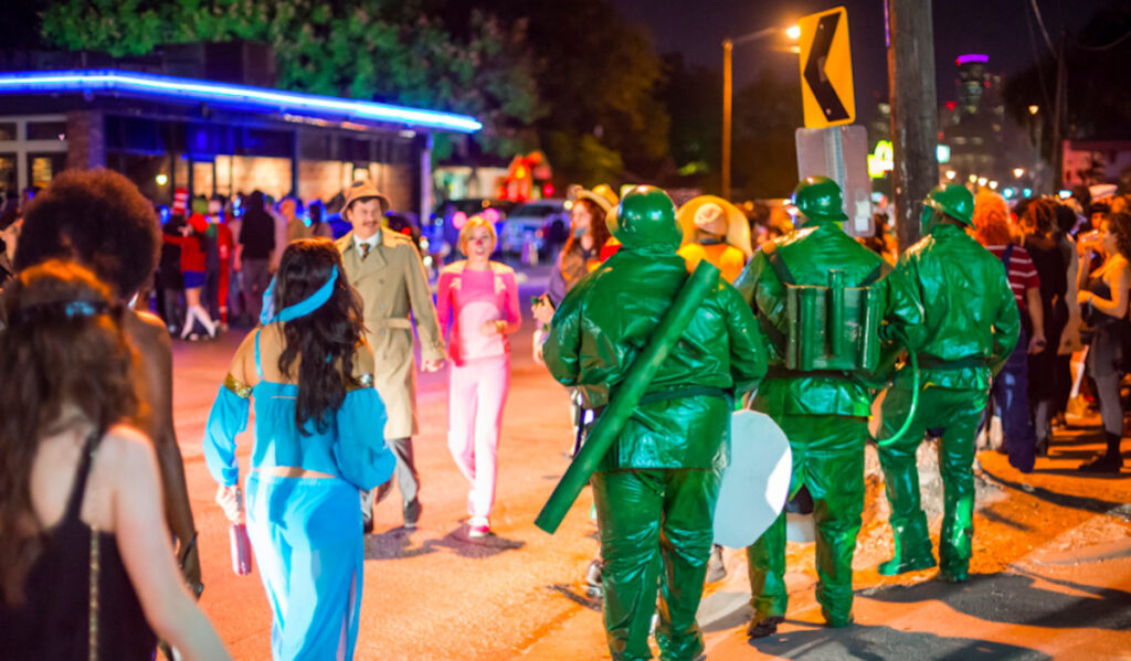 People in green military costumes and others cross the street