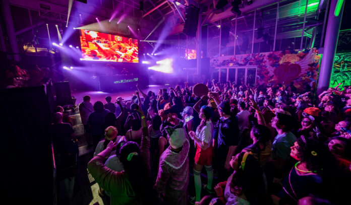 A crowded dance floor of people in costume