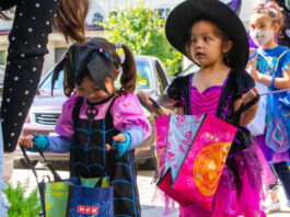Two kids with bags getting candy