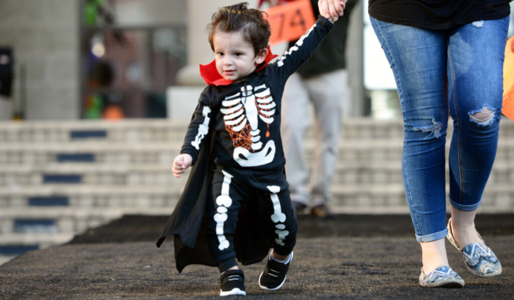 A child in a skeleton costume walks in a contest