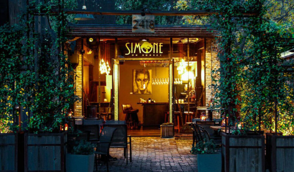 The entrance to Simone on Sunset with leafy green plants around it