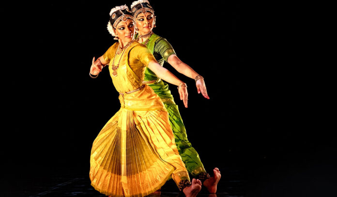 Sisters Aparna and Ashwini Ramaswamy perform a movement in sync on stage