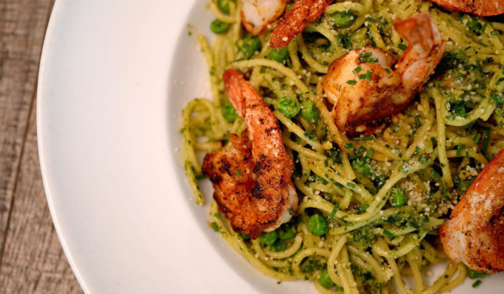 A plate of pasta with grilled shrimp