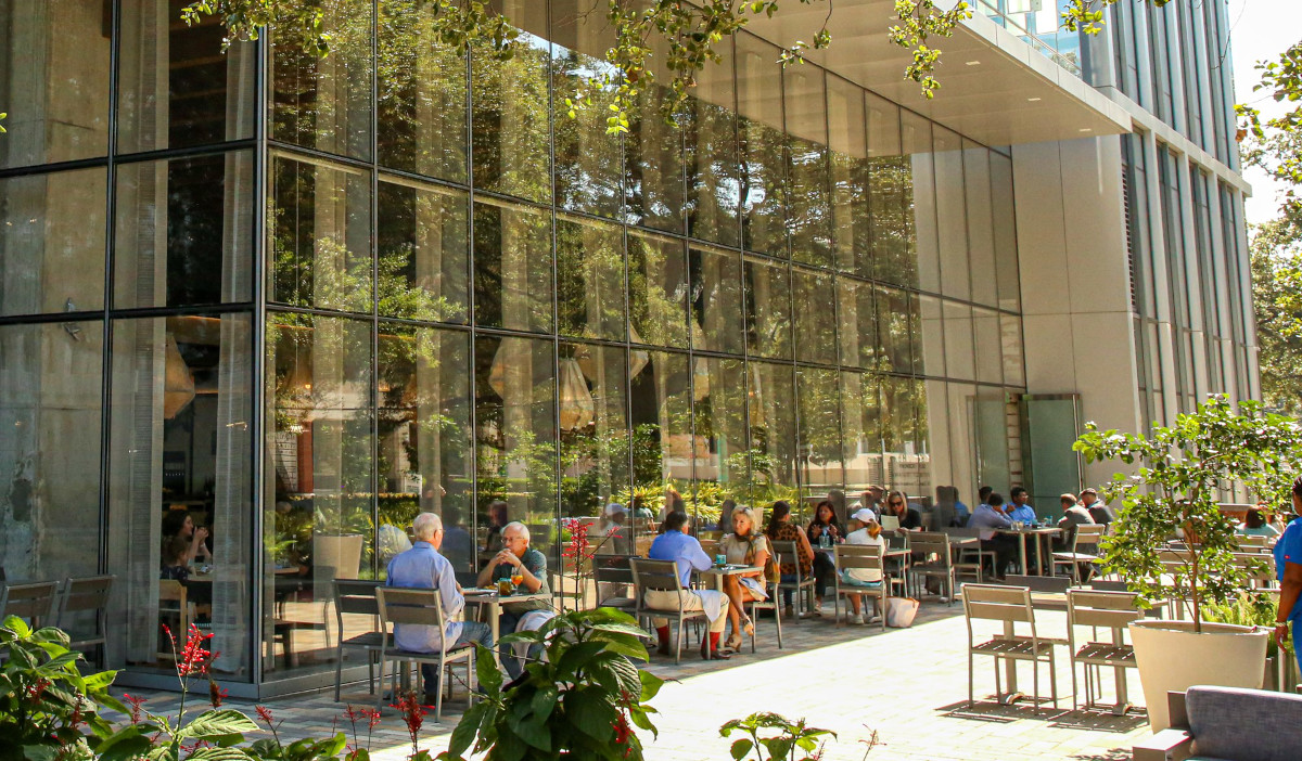 The outdoor patio at Eunice, shaded by green plants and trees