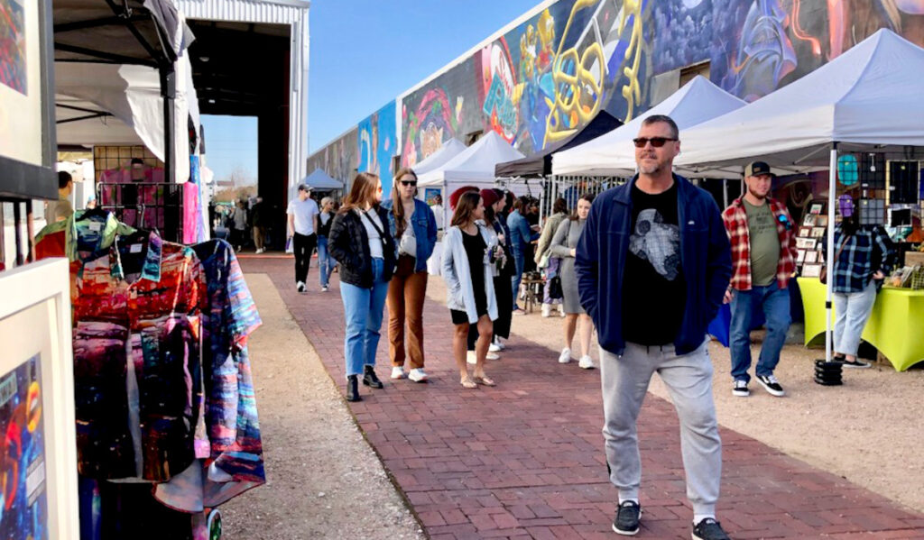 Groups of people walking between market stalls