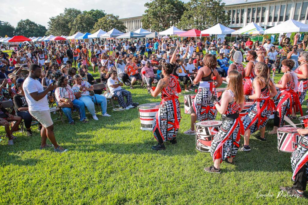 People sit in rows to watch an African drumming group perform