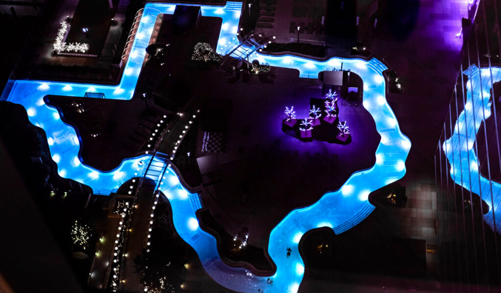 A Texas-shaped rooftop pool features holiday lights installations