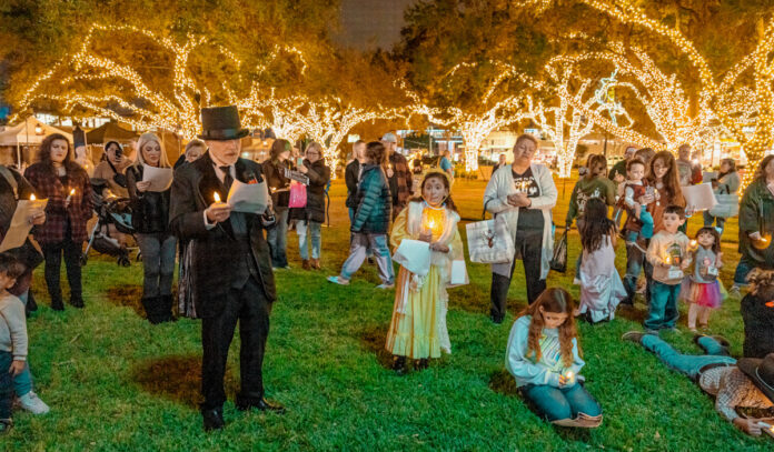 A crowd of children and families singing Christmas carols