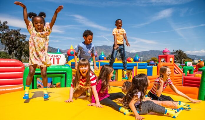 Children jumping in a yellow inflatable bounce park