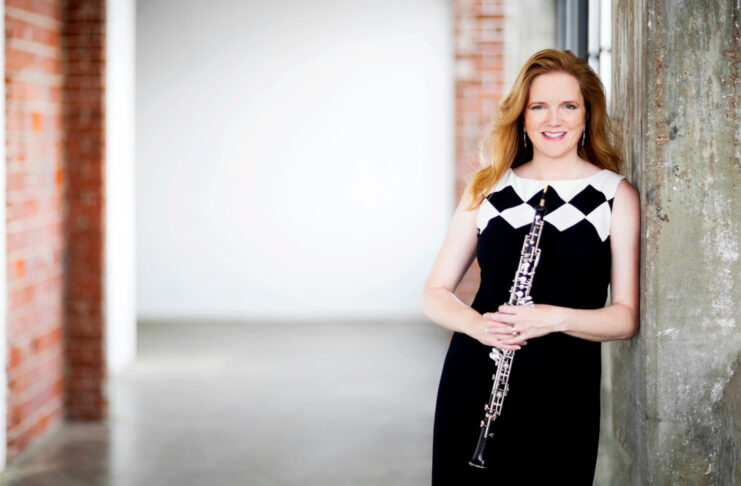 Alecia Lawyer posing while holding an oboe