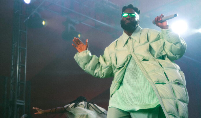 Tobe Nwigwe performing on stage in a mint-colored jacket