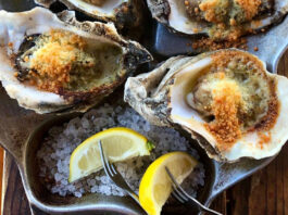 Three grilled oysters with lemon slices