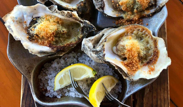 Three grilled oysters with lemon slices