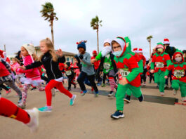 Kids in elf and santa outfits running in a race