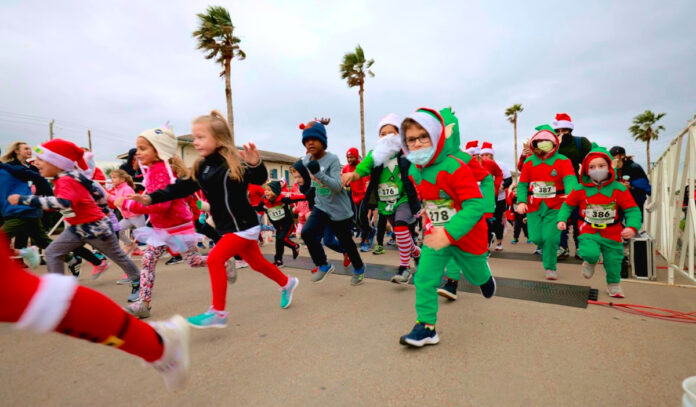 Kids in elf and santa outfits running in a race