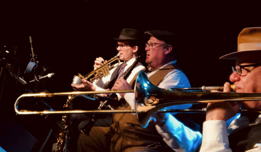 Three men with brass instruments performing