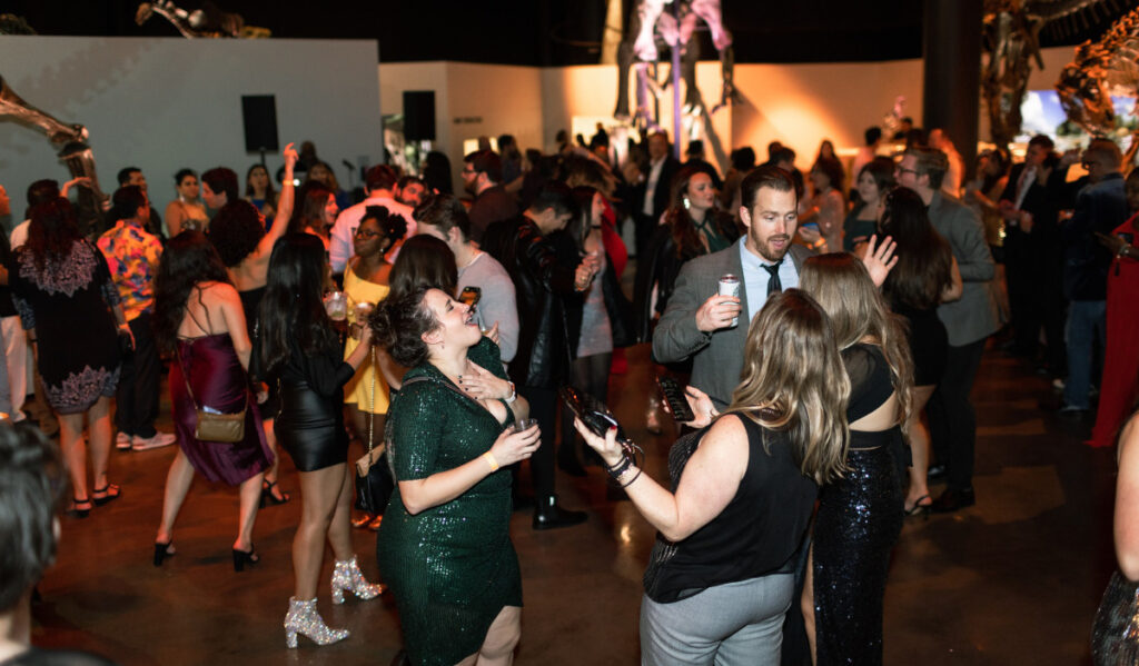 Party goers dance in the Paleontology Hall of HMNS