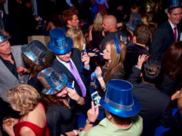 A crowd of people in New Year's hats and party favors