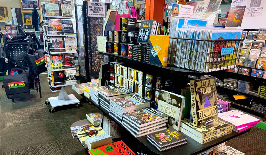 A shelf of music-themed books and Houston-themed art