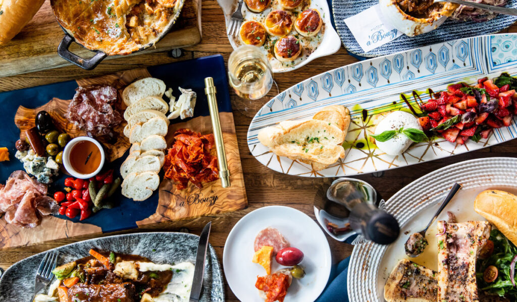 An overhead image of a brunch spread with multiple dishes and charcuterie