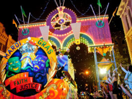 A festive Mardi Gras parade float passes through a crowd of revelers