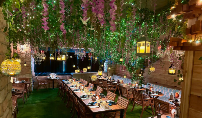 A dining room with hanging green and pink plants