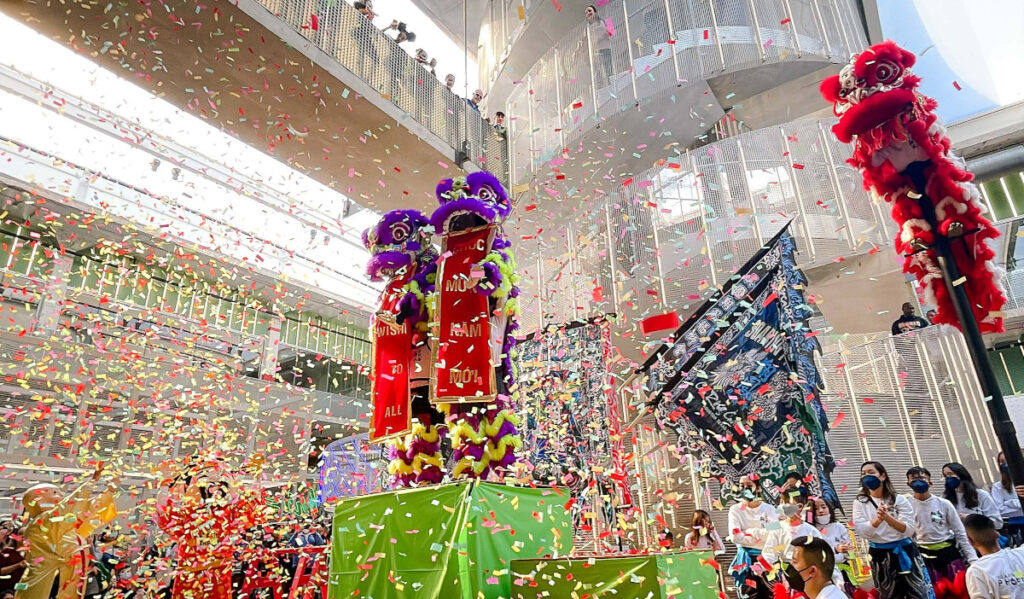 Two dragons standing in the Post Houston food hall with confetti in the air