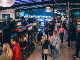 People walking through rows of arcade games