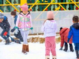 Children standing and playing in mounds of snow