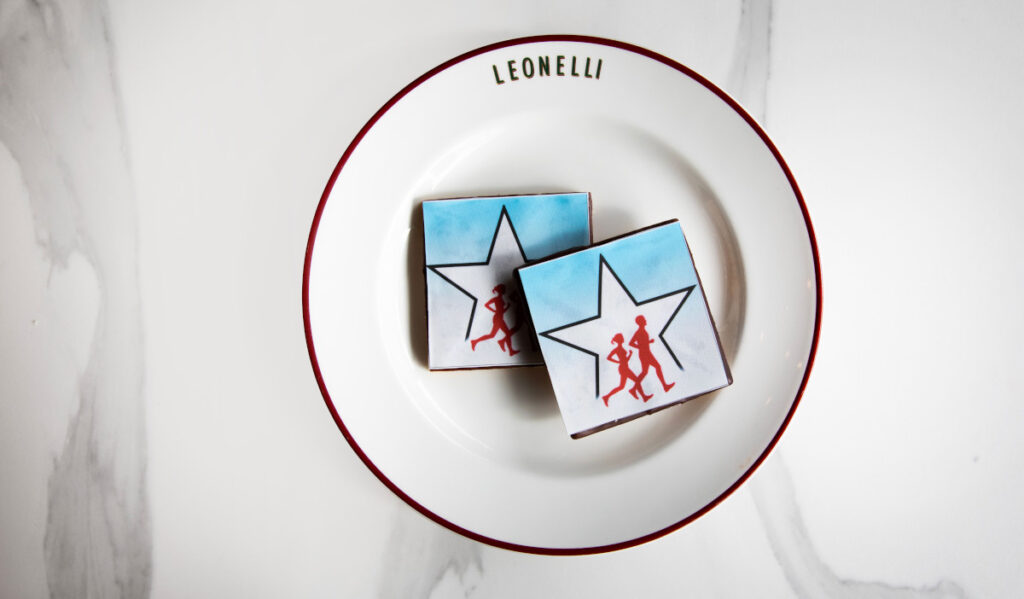 A plate with two cookies with decoration of two runners on a white star with a blue and white background