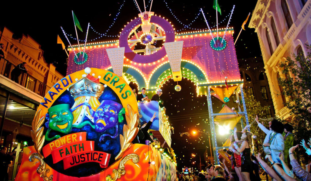 A festive Mardi Gras parade float passes through a crowd of revelers