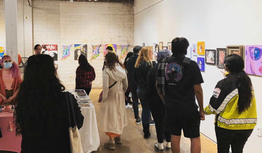 People walking past artwork on display in a gallery