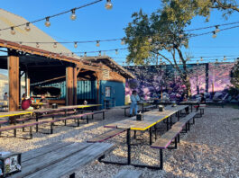 An outdoor patio on a sunny day with string lights overhead