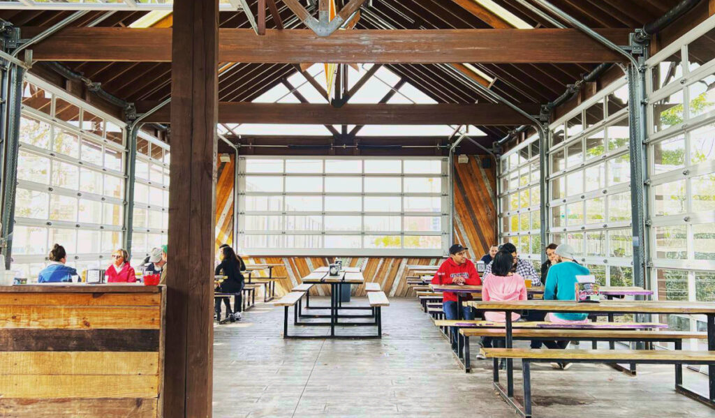 A brightly-lit covered patio with people at tables 