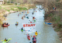 Register now to paddle in the 54th Buffalo Bayou Partnership Regatta Paddlers in canoes and kayaks passing under a Starting Line