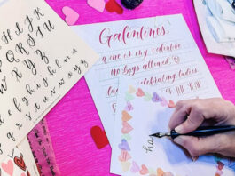 A hand writing calligraphy with practice sheets that read "Galentine's"