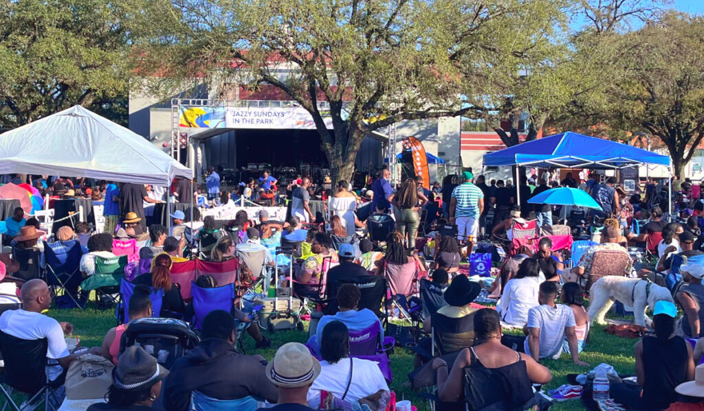 An outdoor concert with rows of people in lawn chairs